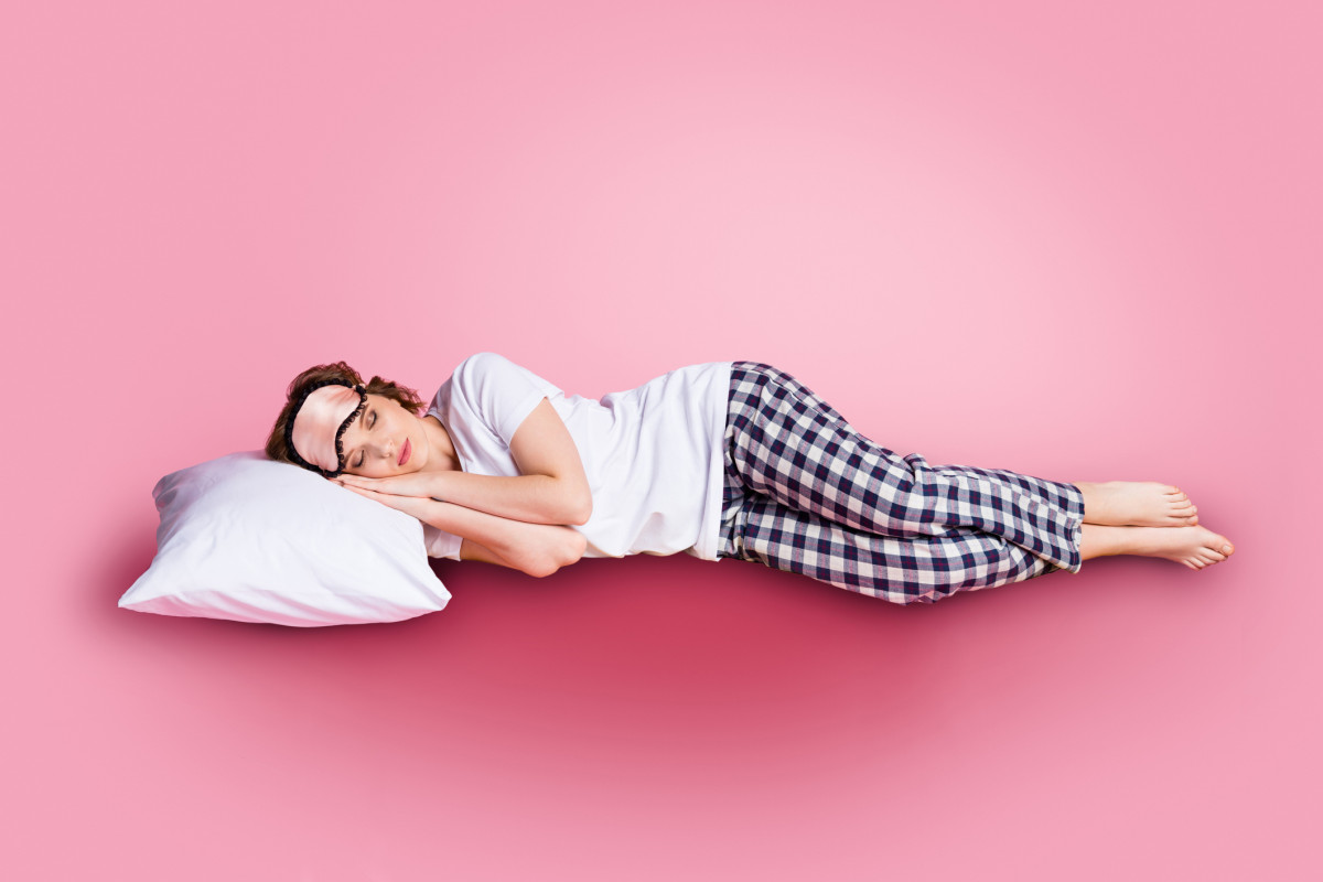 Vrouw in pyjama slapend roze achtergrond
